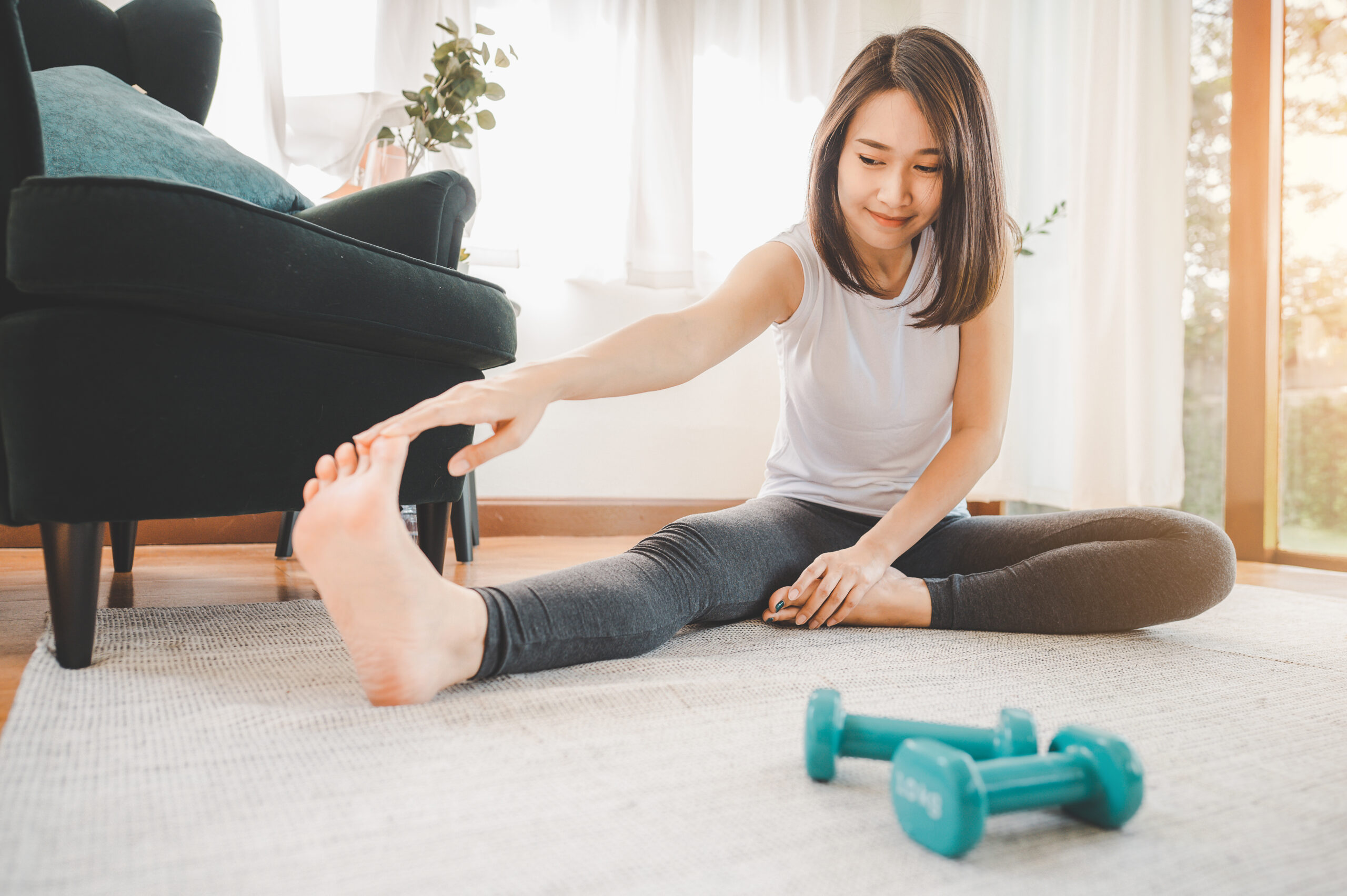 Asian woman stretching her leg  at home